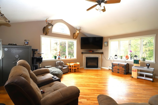 living room featuring light hardwood / wood-style floors, lofted ceiling, ceiling fan, and plenty of natural light