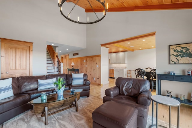 living room featuring wood ceiling, light hardwood / wood-style floors, high vaulted ceiling, wooden walls, and a chandelier