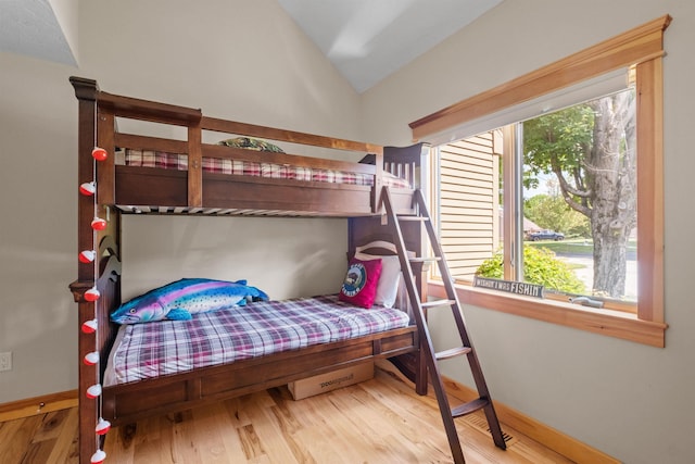 bedroom with vaulted ceiling and hardwood / wood-style floors