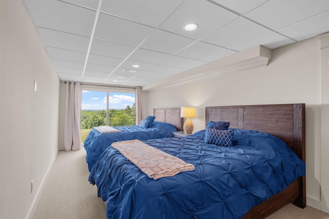 bedroom featuring light carpet and a drop ceiling