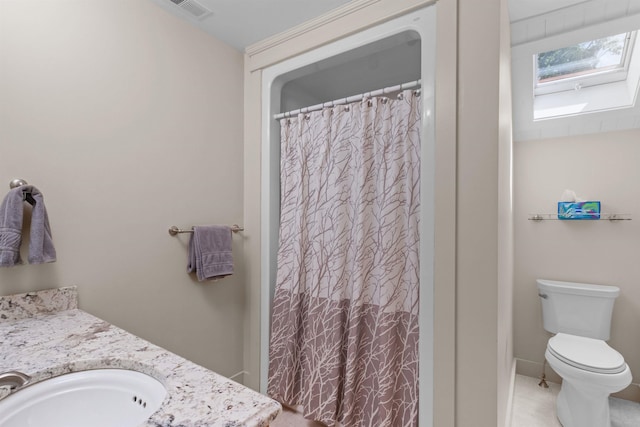 bathroom with walk in shower, vanity, toilet, and a skylight