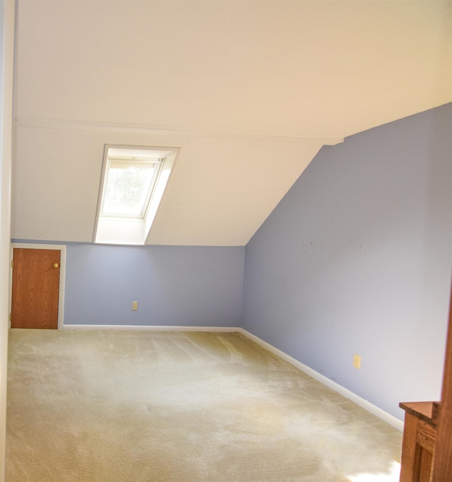 additional living space with carpet and vaulted ceiling with skylight