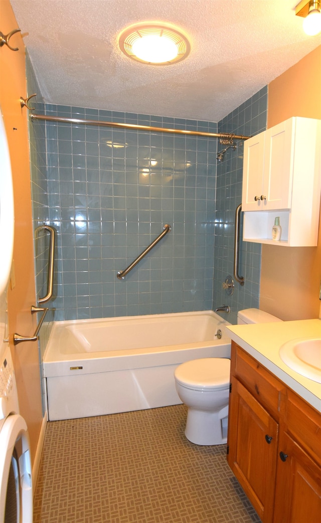 full bathroom featuring toilet, tiled shower / bath, a textured ceiling, and vanity