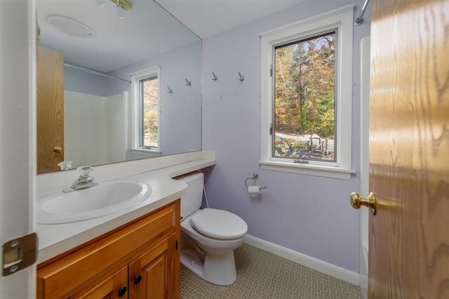 bathroom with toilet, vanity, a shower, and tile patterned flooring