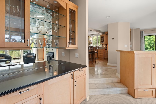 bar featuring plenty of natural light and light brown cabinets