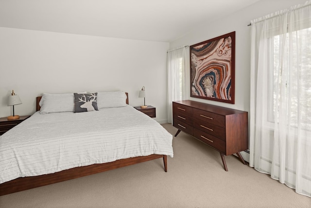 bedroom with light colored carpet and baseboard heating