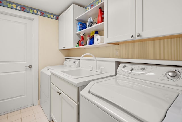 washroom with washing machine and clothes dryer, sink, light tile patterned floors, and cabinets