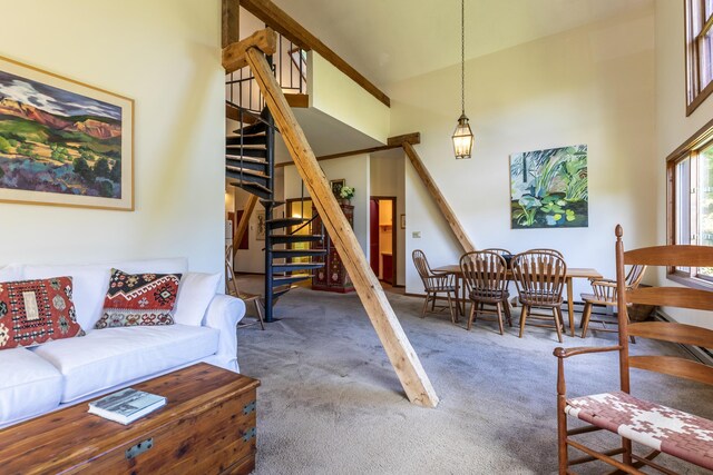 27 Lawrence Hill Rd Unit 5, Weston, VT 05161 - living area with carpet floors, high vaulted ceiling, and stairway
