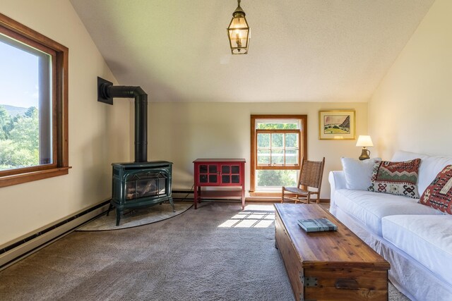 27 Lawrence Hill Rd Unit 5, Weston, VT 05161 - carpeted living room featuring lofted ceiling, a wood stove, and a baseboard radiator
