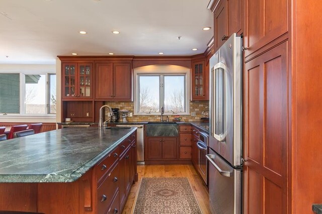 kitchen featuring light hardwood / wood-style flooring, stainless steel appliances, sink, and a healthy amount of sunlight