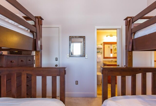 carpeted bedroom featuring connected bathroom