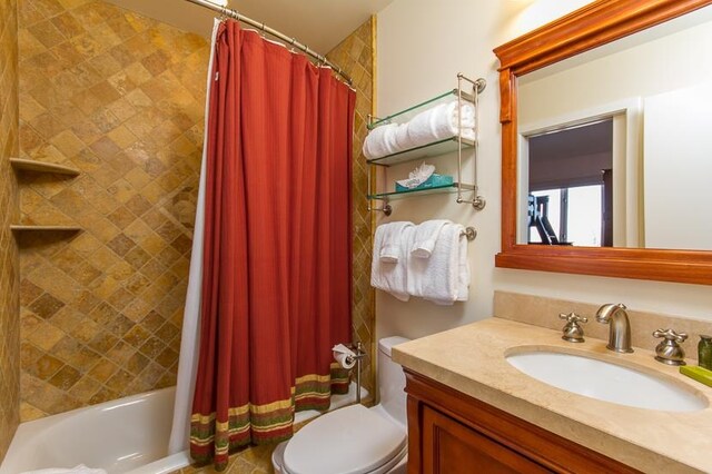 full bathroom featuring shower / bath combo with shower curtain, vanity, and toilet