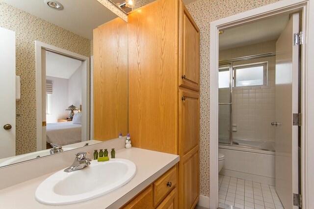 full bathroom featuring enclosed tub / shower combo, vanity, toilet, and tile patterned floors