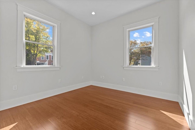 empty room with baseboards and wood finished floors
