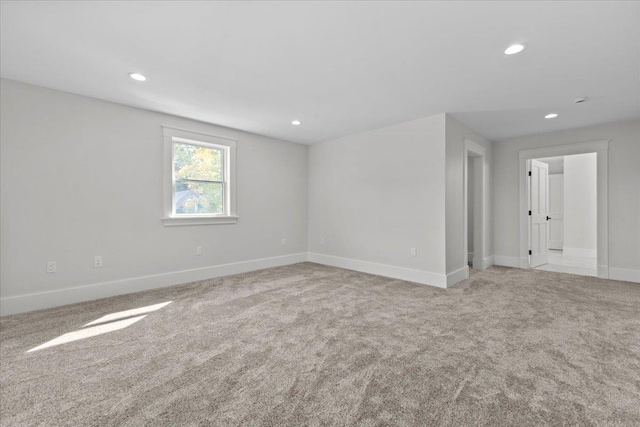carpeted empty room featuring baseboards and recessed lighting