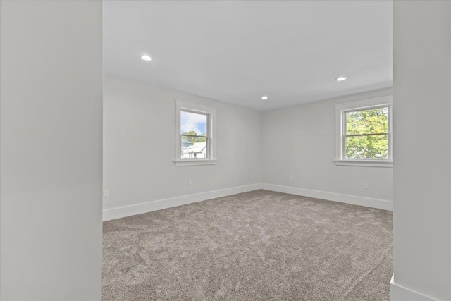 carpeted empty room with recessed lighting, baseboards, and a wealth of natural light