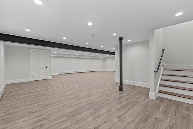 basement featuring light hardwood / wood-style floors and a baseboard heating unit