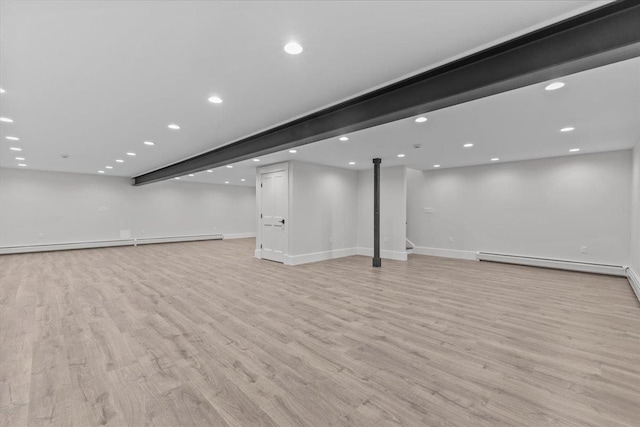 finished basement featuring baseboards, recessed lighting, light wood-style flooring, and baseboard heating