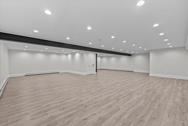 basement featuring baseboards, recessed lighting, light wood-style floors, and baseboard heating