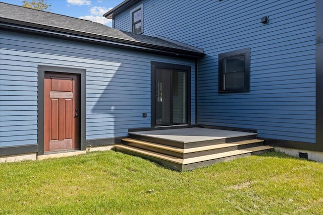entrance to property featuring a lawn