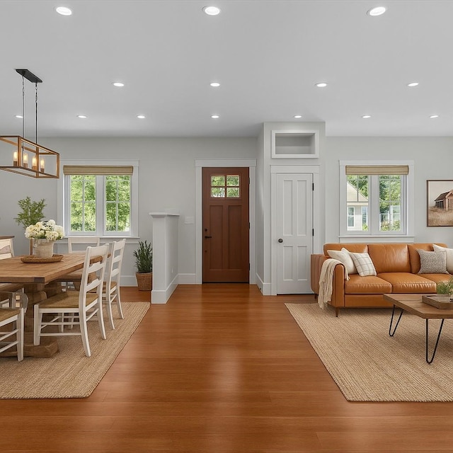living room with recessed lighting, baseboards, and light wood-type flooring