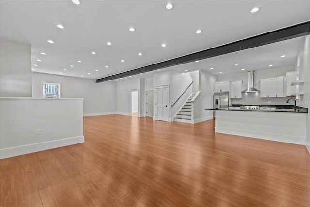 unfurnished living room featuring light wood-type flooring and sink