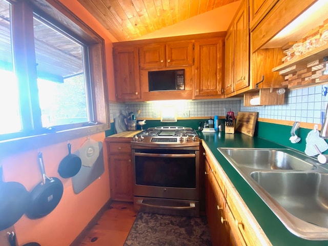 kitchen featuring wood ceiling, sink, stainless steel range with gas stovetop, vaulted ceiling, and decorative backsplash