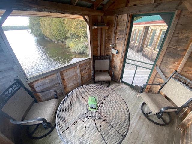 sunroom / solarium with a water view and a healthy amount of sunlight