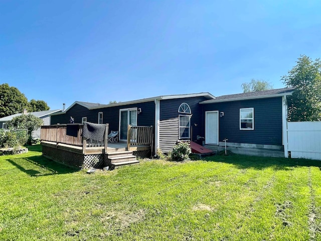 back of house with a deck and a yard