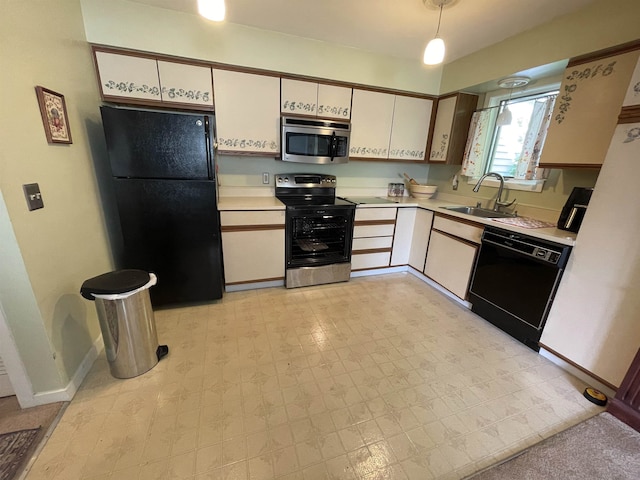 kitchen featuring sink, white cabinets, black appliances, and decorative light fixtures