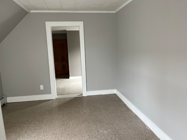 spare room featuring crown molding, vaulted ceiling, and baseboard heating