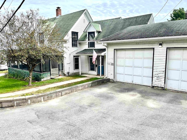 view of front of house featuring a sunroom and a garage