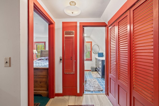 hall featuring light hardwood / wood-style flooring and lofted ceiling