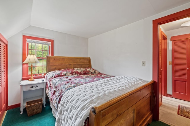 bedroom with vaulted ceiling, a closet, and carpet floors