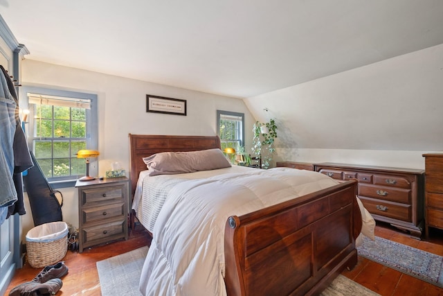 bedroom with multiple windows, light hardwood / wood-style floors, and vaulted ceiling