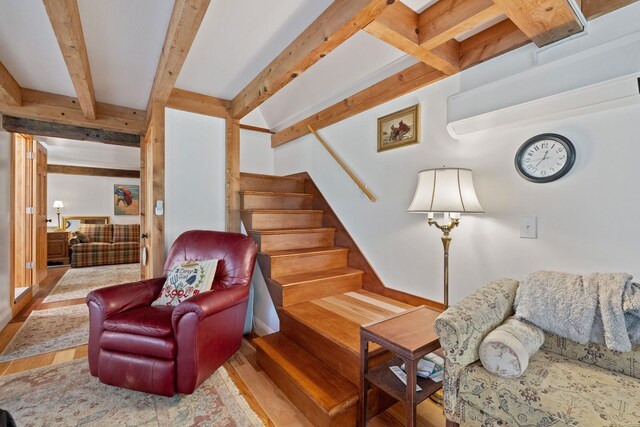 living room with beamed ceiling and hardwood / wood-style floors