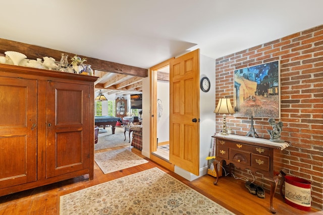 entrance foyer featuring billiards, light hardwood / wood-style flooring, and beam ceiling