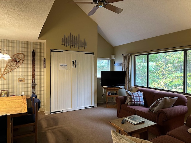 carpeted living area featuring baseboards, a textured ceiling, high vaulted ceiling, and a ceiling fan