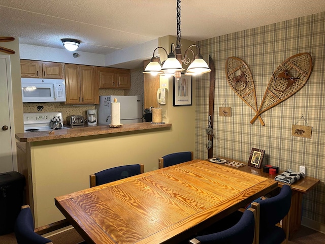 dining space featuring a notable chandelier and a textured ceiling