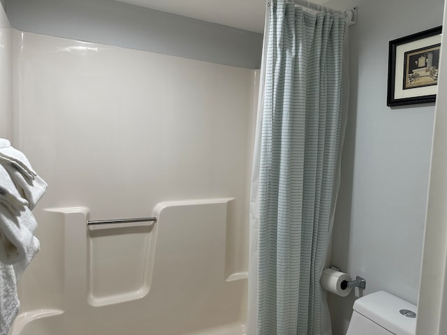 bathroom with shower / bath combo with shower curtain and toilet