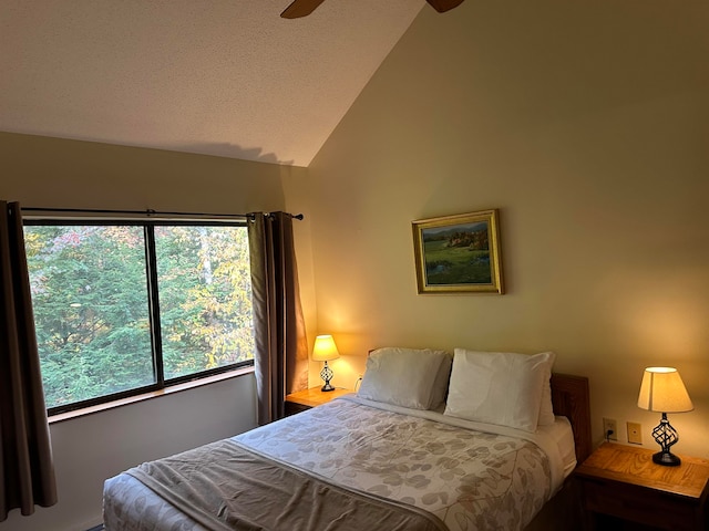 bedroom featuring ceiling fan, a textured ceiling, and lofted ceiling