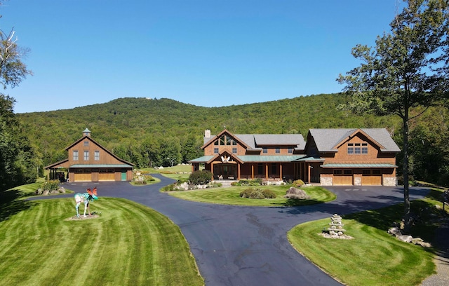 view of front facade featuring a mountain view, a front lawn, and a garage