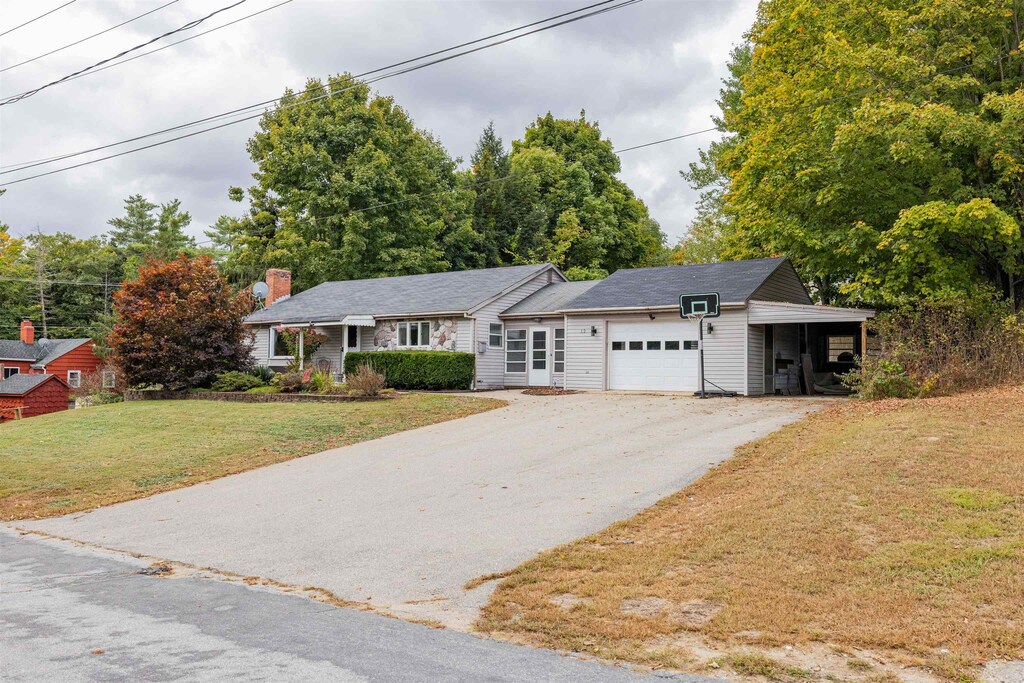 ranch-style home featuring a garage and a front lawn