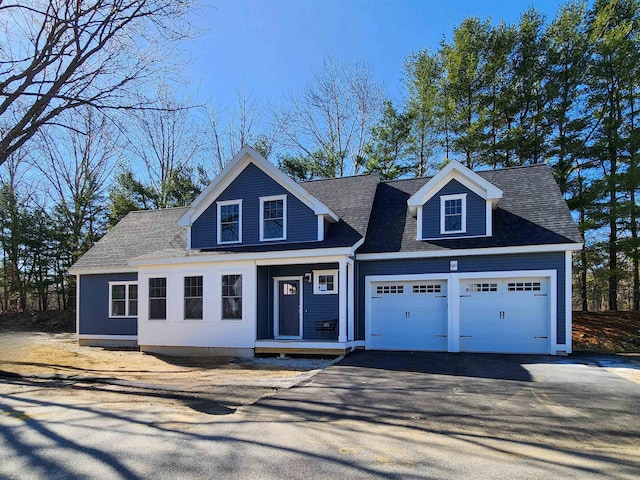 view of front facade featuring an attached garage, aphalt driveway, and a shingled roof