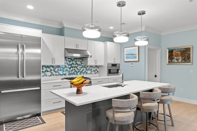 kitchen featuring white cabinets, appliances with stainless steel finishes, hanging light fixtures, and sink