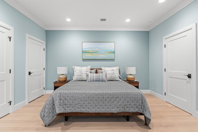 bedroom with ornamental molding and light hardwood / wood-style floors