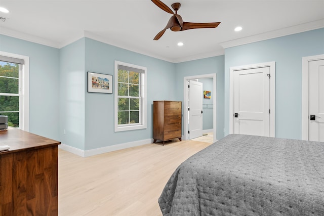 bedroom featuring ceiling fan, light wood-type flooring, crown molding, and ensuite bathroom