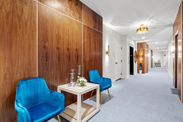 living area with wooden walls and light carpet