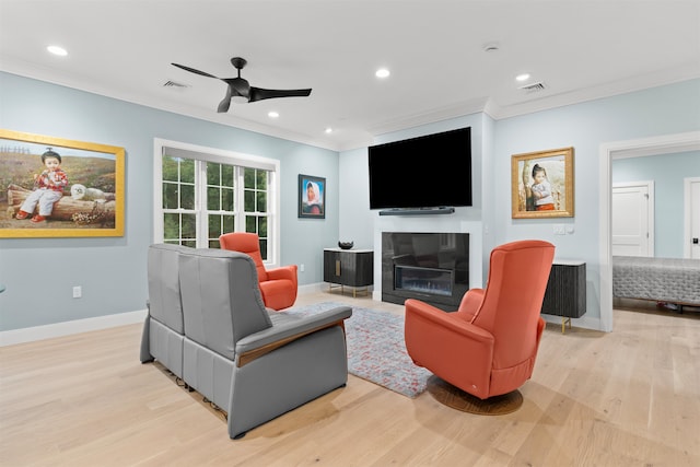 living room with light hardwood / wood-style flooring, ceiling fan, and crown molding