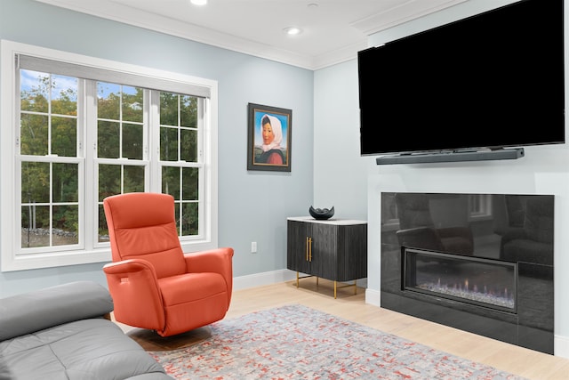 living room with light wood-type flooring, ornamental molding, and a wealth of natural light